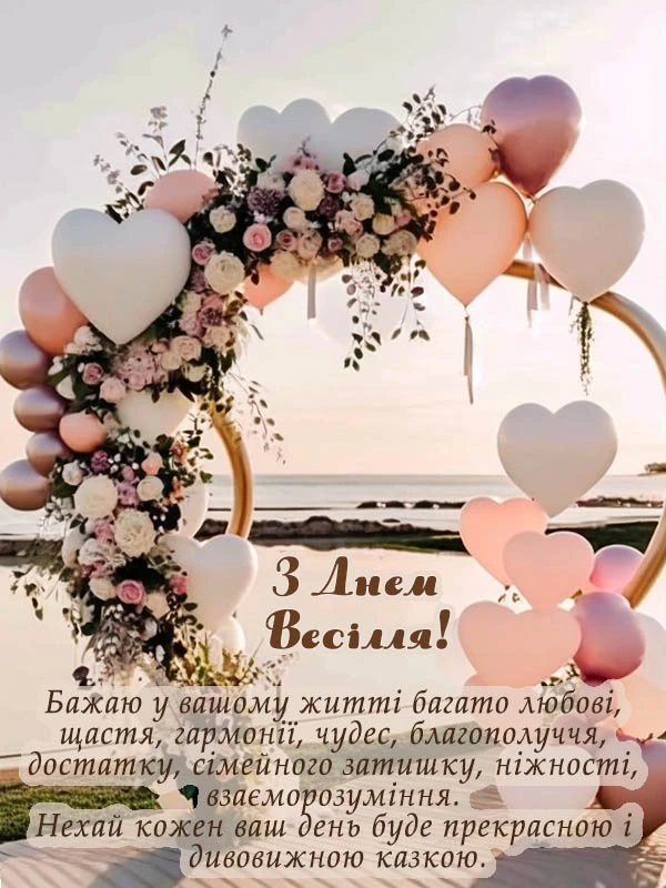 Весільна арка з квітами та серцевими кульками на фоні заходу сонця.
