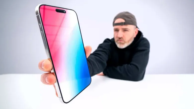 Чоловік тримає новий смартфон Apple в руках.
